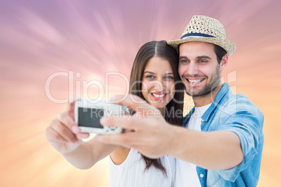 Composite image of happy hipster couple taking a selfie