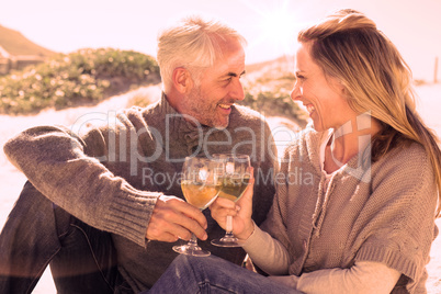 Couple enjoying white wine on picnic at the beach