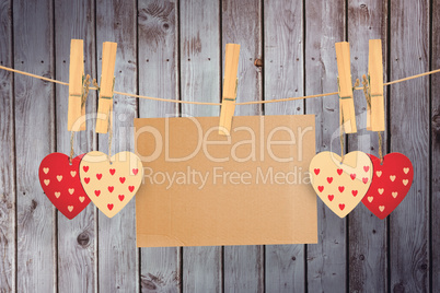 Composite image of hearts hanging on line with card