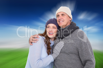 Composite image of couple in warm clothing embracing