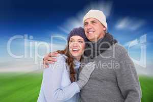 Composite image of couple in warm clothing embracing