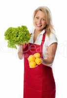 Frau mit Schürze präsentiert Salat und Zitronen