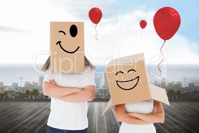 Composite image of mature couple wearing boxes over their heads