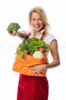 Blonde Frau mit Schürze zeigt einen Brokkoli