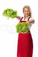 Blonde Frau mit Schürze zeigt Salatsorten