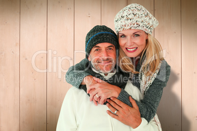 Composite image of happy couple in winter fashion embracing