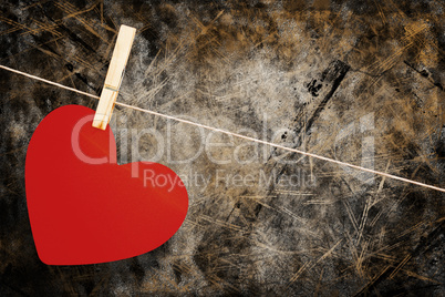 Composite image of heart hanging on line