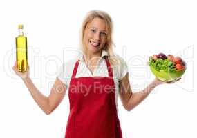 Frau präsentiert eine Gemüseschale und eine Flasche Oel