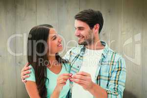 Composite image of happy young couple holding new house key