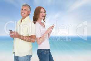Composite image of casual couple sending text messages