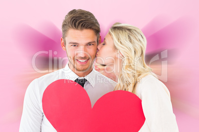 Composite image of attractive young couple holding red heart