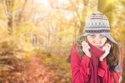 Composite image of cold redhead wearing coat and hat