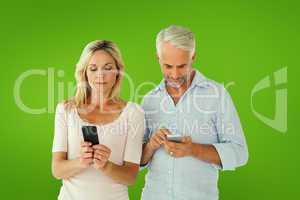 Composite image of happy couple texting on their smartphones