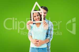 Composite image of happy young couple with house shape