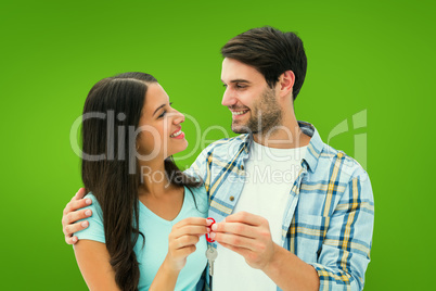 Composite image of happy young couple holding new house key