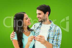 Composite image of happy young couple holding new house key