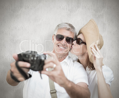 Composite image of vacationing couple taking photo