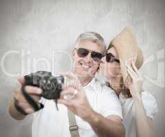 Composite image of vacationing couple taking photo