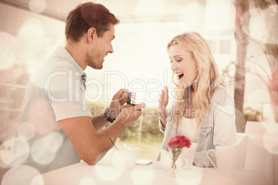 Man proposing marriage to his shocked blonde girlfriend