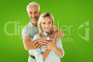 Composite image of happy couple smiling at camera and embracing