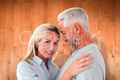 Composite image of happy couple standing and smiling at camera