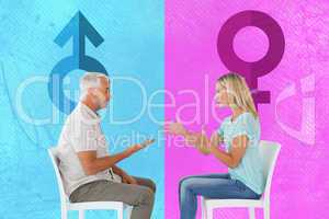 Composite image of unhappy couple sitting on chairs having an ar