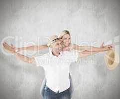 Composite image of happy man giving his partner a piggy back