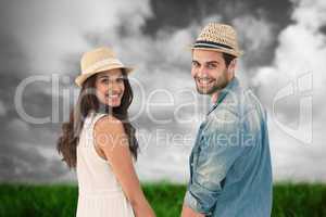 Composite image of happy hipster couple holding hands and smilin