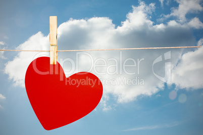 Composite image of heart hanging on line