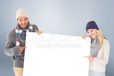 Composite image of attractive couple in winter fashion showing p