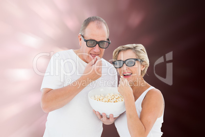 Composite image of mature couple wearing 3d glasses eating popco