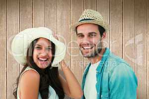 Composite image of happy hipster couple smiling at camera