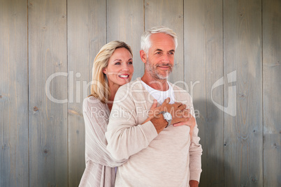 Composite image of happy couple standing and hugging