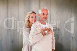 Composite image of happy couple standing and hugging