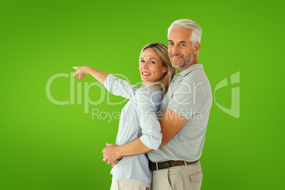 Composite image of happy couple smiling at camera and pointing