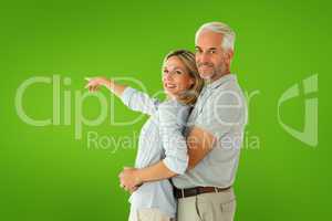 Composite image of happy couple smiling at camera and pointing