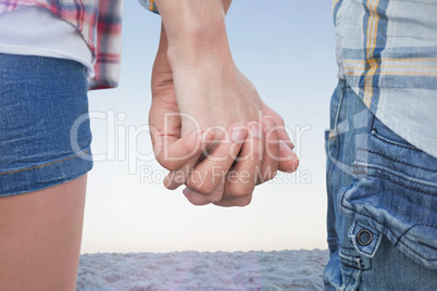 Composite image of couple in check shirts and denim holding hand