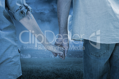 Composite image of couple holding hands in park