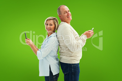 Composite image of happy mature couple using their smartphones