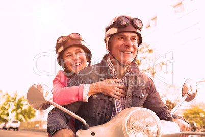 Happy senior couple riding a moped