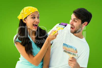 Composite image of happy young couple painting together and laug