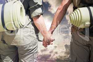 Composite image of hitch hiking couple standing holding hands on