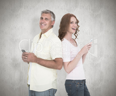 Composite image of casual couple sending text messages