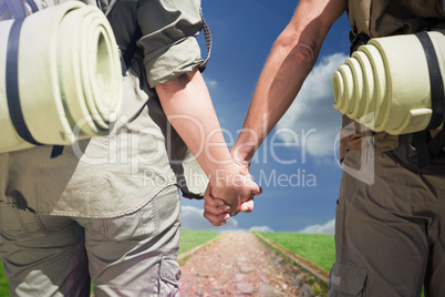 Composite image of hitch hiking couple standing holding hands on