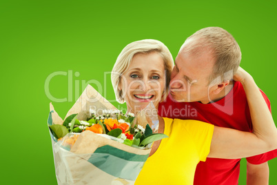 Composite image of mature man kissing his partner holding flower