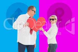 Composite image of older affectionate couple holding red heart s