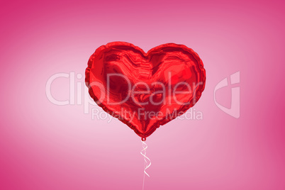 A large red heart balloon on pink background