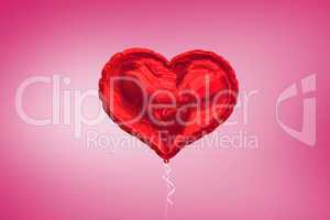 A large red heart balloon on pink background