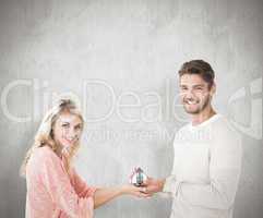 Composite image of attractive couple holding miniature house mod