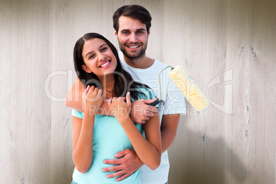 Composite image of happy young couple painting together